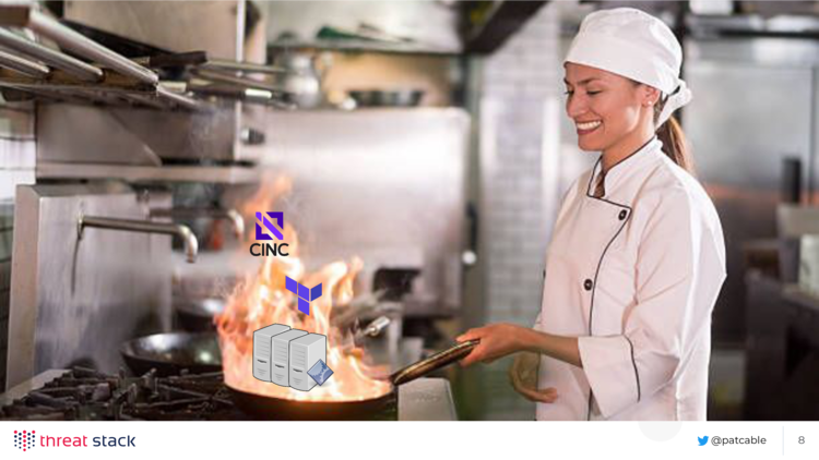 A chef in a commercial kitchen stirring a pan on fire, wtih the Cinc